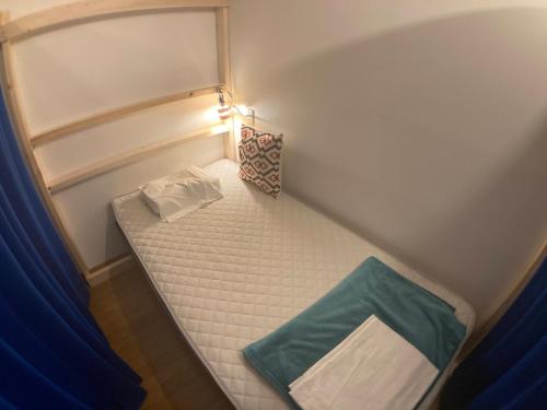a small room with a small bed in the corner at Guesthouse LuLuLu 無料朝食&夕食ｶﾚｰ 街まで電車8分 ﾛｰｿﾝ隣 in Kochi