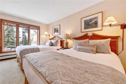 a hotel room with two beds and a window at Ski In, Ski Out Studio Condo In The Heart Of Lionshead Village With Hot Tub And Pool Access in Vail
