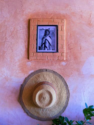 a picture of a man on a wall with a hat at Auberge Ayouze in Aït Ben Haddou