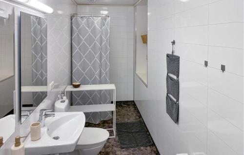 a white bathroom with a toilet and a sink at Lovely Home In Ormaryd With Sauna in Ormaryd