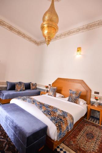 a bedroom with two beds and a chandelier at Riad Dilar Fes & Spa in Fès