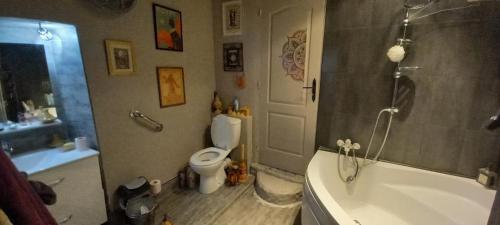 une salle de bain avec toilettes, baignoire et lavabo dans l'établissement Au cœur de nos pérégrinations, à Breil-sur-Roya