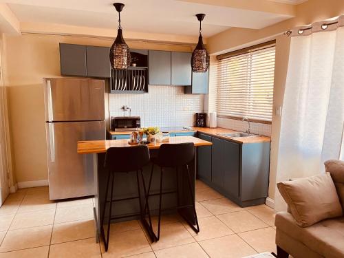 a kitchen with a refrigerator and a counter with stools at Aparta-Hotel Carmela #2 in Siguatepeque