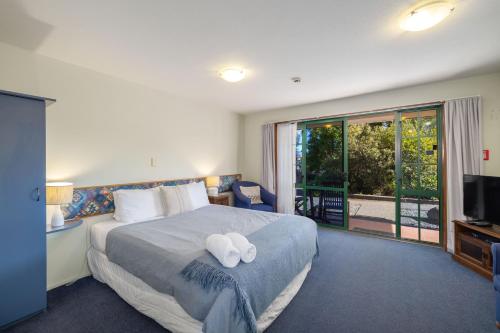 a bedroom with a bed with two white towels on it at 112 on Beach in Kaikoura