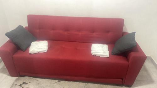 a red couch with two pillows on top of it at Casa céntrica y amplia in Celaya