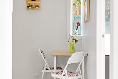 a table with two chairs and a vase with flowers at Single Room - Quaint Spot in Marayong - Centrally Located - Shared Bathroom in Blacktown