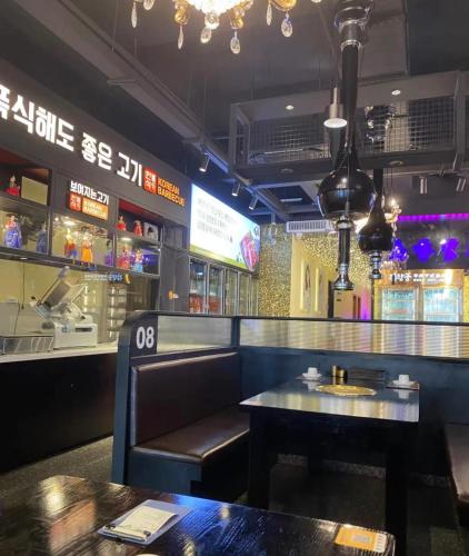 a bar with a table and a bench in a restaurant at Slow Cloud Residence - Gongbei Port Zhuhai Station in Wan-tzu