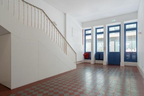 an empty hallway with stairs and doors in a building at Habitatio - Aliados by LuxiStay in Porto