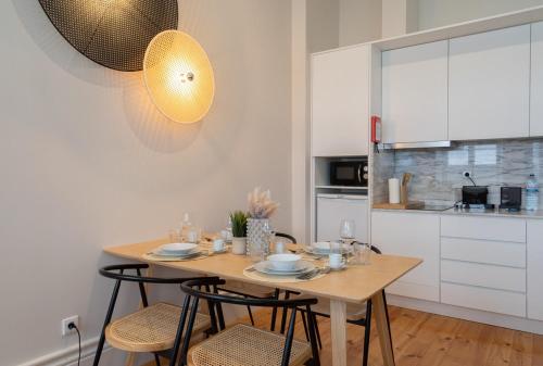 a kitchen with a wooden table and chairs in a room at Habitatio - Aliados by LuxiStay in Porto