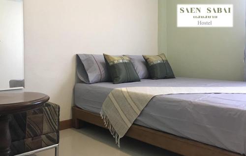a bedroom with a bed and a table at Saen Sabai Hostel in Lat Krabang