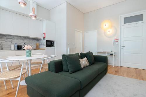 a living room with a green couch and a table at Habitatio - Aliados by LuxiStay in Porto