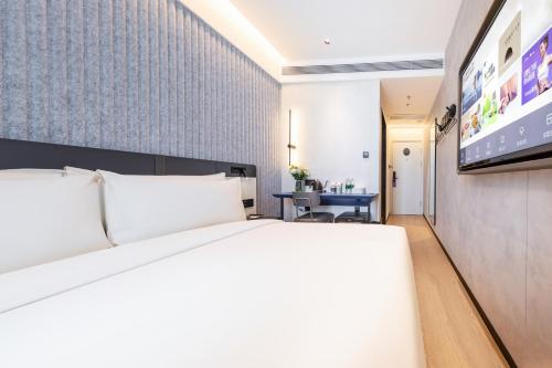 a hotel room with a bed and a flat screen tv at Atour Light Hotel Beijing Zhongguancun Renmin University in Beijing