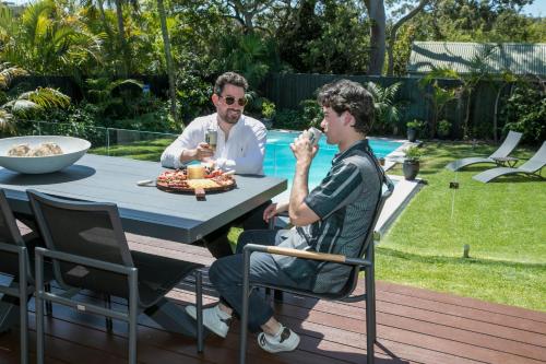 two men sitting at a table eating food at 'the Governor Ii' - Designer Wonderland, Avalon in Avalon