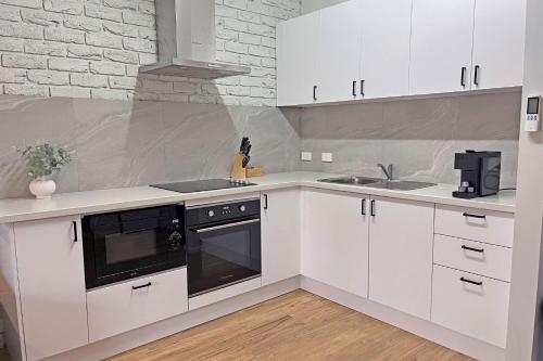 a kitchen with white cabinets and a stove and a sink at BIG4 Tasman Holiday Parks - Warrnambool in Warrnambool