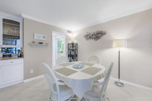 a white dining room with a table and chairs at Heated 2 Bath Waterfront Upscale Condo in Marco Island