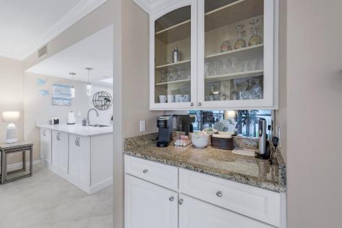 a kitchen with white cabinets and a counter at Heated 2 Bath Waterfront Upscale Condo in Marco Island