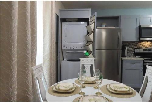 a kitchen with a table with chairs and a refrigerator at Nataj suites at Tampa in Tampa