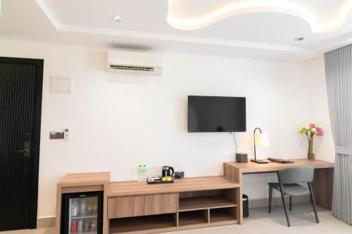 a room with a desk and a tv on a wall at Chaiya Palace Hotel in Phnom Penh