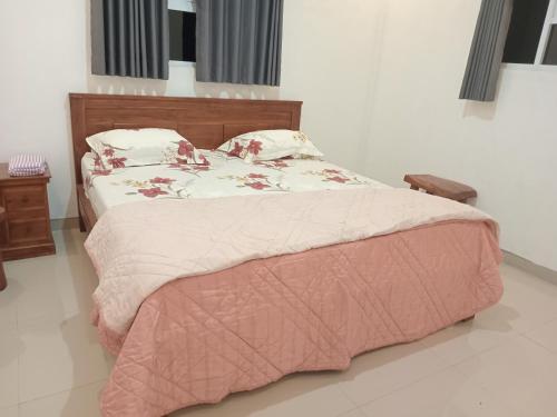 a bedroom with a bed with a pink blanket at Ubud Suites Batuan in Sukawati