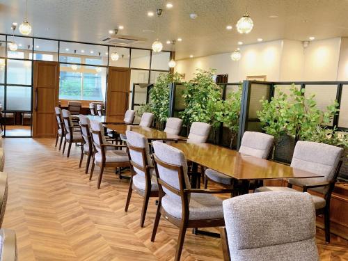 a conference room with tables and chairs and plants at Green Rich Hotel Kobe Sannomiya (Artificial hot spring Futamata Yunohana) in Kobe