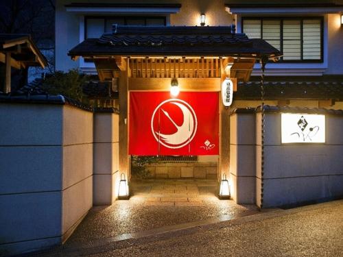 a building with a flag on the side of it at Yunokura Tsuruya in Makago
