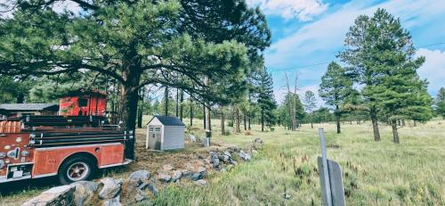 a red fire truck is parked in a field at Cabin with a Mountain view 6B in Williams