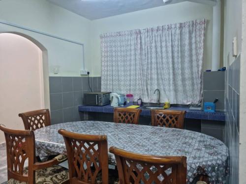 a kitchen with a table and chairs and a sink at PD BATU 9 Cocobay Resort Condominium in Kampong Tanah Merah