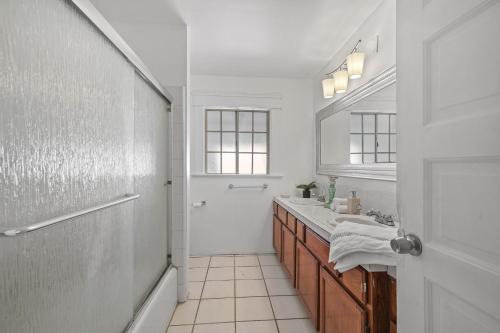 a white bathroom with a sink and a mirror at Spacious Chic 5 Bedroom Perfect for Large Group With parking in Los Angeles