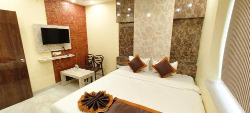 a hotel room with a bed and a television at Hotel Divine Chariot in kolkata