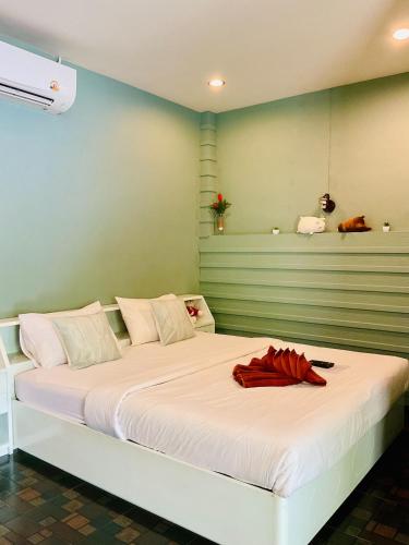 a bedroom with a white bed with a red robe on it at Naris phu view resort in Ban Pan Cho