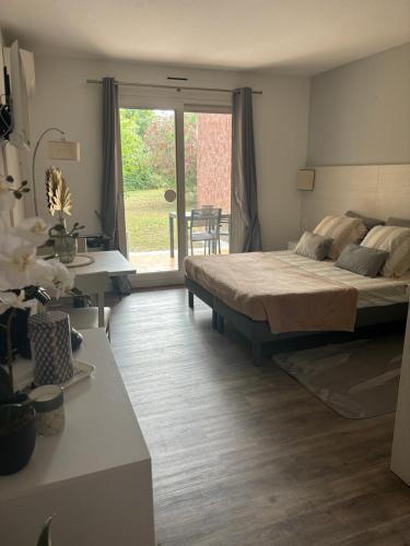 une chambre avec un lit, un bureau et une fenêtre dans l'établissement Logements T1 et T2 - Les Hameaux de Camargue, à Arles