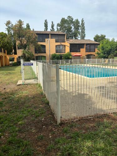 une clôture en face d'une piscine dans l'établissement Logements T1 et T2 - Les Hameaux de Camargue, à Arles
