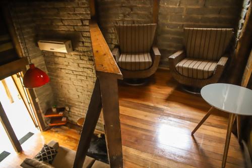 a room with two chairs and a table in a room at Chalé Casa de Pedra, Vivenda Serra Velha, Chalés de Montanha in Timbe do Sul