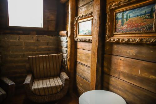 a room with a chair and a picture on the wall at Chalé Casa de Pedra, Vivenda Serra Velha, Chalés de Montanha in Timbe do Sul