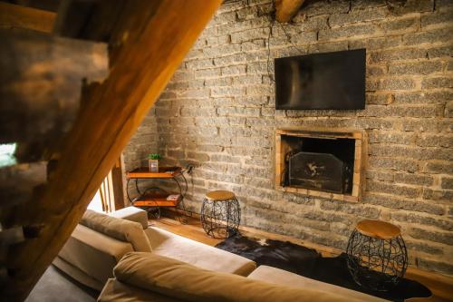 a living room with a brick wall with a fireplace at Chalé Casa de Pedra, Vivenda Serra Velha, Chalés de Montanha in Timbe do Sul