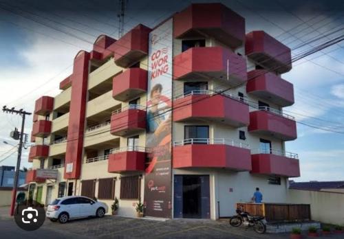 a building with red balconies on the side of it at Residencial Maravilha in Perequê