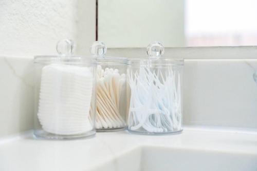 three glass jars sitting on a shelf above a sink at Spacious 4BR w Game Room - 15 min to Seaworld in San Antonio