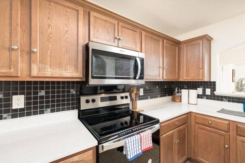 a kitchen with a stove and a microwave at Spacious 4BR w Game Room - 15 min to Seaworld in San Antonio