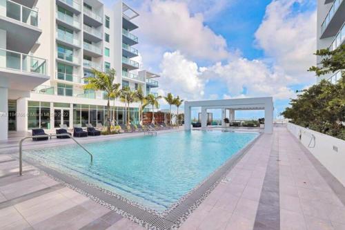 a large swimming pool next to a building at LUXURY 1 BDRM/1B APT IN MIAMI DESIGN DISTRICT AREA in Miami