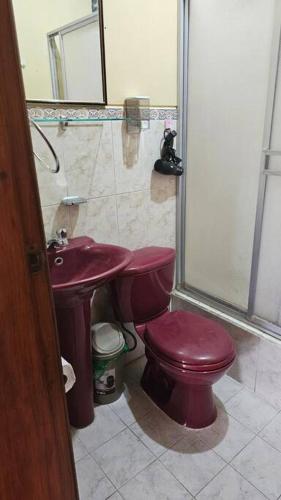 a bathroom with a red toilet and a sink at Lindo Departamento a estrenar in Latacunga