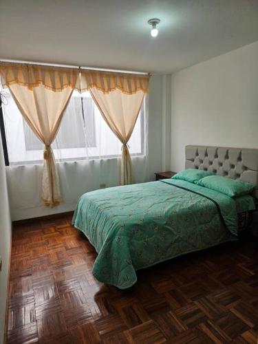a bedroom with a bed and a window with curtains at Lindo Departamento a estrenar in Latacunga