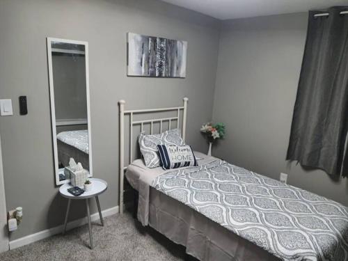 a bedroom with a bed and a table and a mirror at Stunning 2 bedroom and 2 bath mobile home in Doylestown