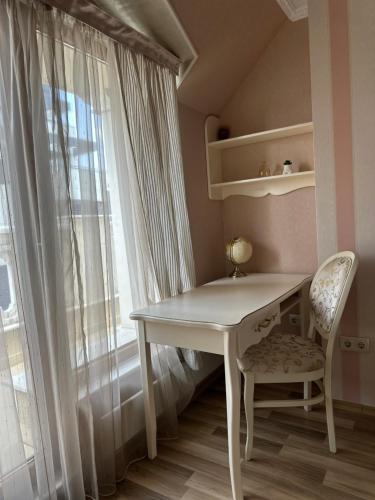 a white table and a chair next to a window at Yo Two - Central Varna Lux Apartment with Parking in Varna City