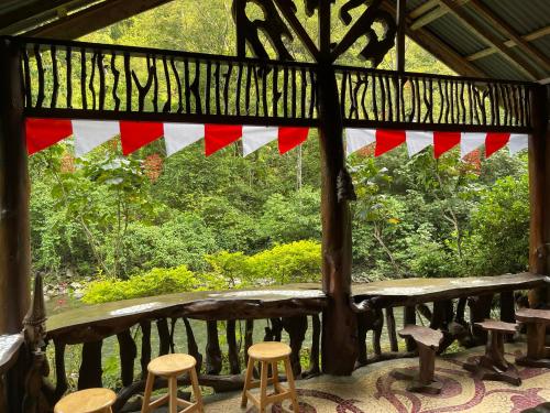 a porch with red and white flags and stools at Kupu Kupu Garden Guest House & Cafe in Bukit Lawang