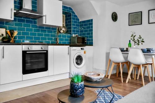 a kitchen with white cabinets and blue tiles at Morpeth City Centre Home in Morpeth