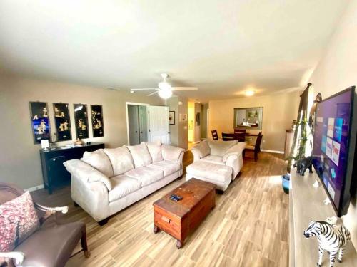 a living room with two white couches and a tv at 3Bed 2Bath Spacious-LakeHomeAceLoc4milesLEGOLAND in Cypress Gardens