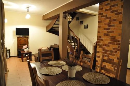 a dining room with a table and chairs and a staircase at Jarefka Niezapomniane Chwile in Ciemno