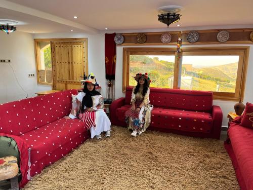 two people sitting on couches in a living room at Sanae house in El Mansoura