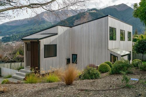 a modern house with mountains in the background at Lake and Mountain Views - Central Queenstown in Queenstown
