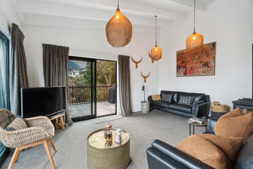 a living room with a couch and a tv at Lake and Mountain Views - Central Queenstown in Queenstown